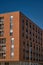 Impressive tall red brick building on the background of the blue sky