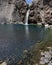 Impressive vertical photo of turquoise light blue waterfall located in the Cajon del Maipo, Andes Mountains called Salto el Yeso,