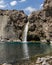 Impressive vertical photo of turquoise light blue waterfall located in the Cajon del Maipo, Andes Mountains called Salto el Yeso,