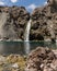 Impressive vertical photo of turquoise light blue waterfall located in the Cajon del Maipo, Andes Mountains called Salto el Yeso,