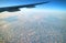 Impressive view of the wing of an airplane flying above the clouds seen from plane window during flight