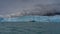 An impressive wall of blue ice rises above the surface of the turquoise lake.