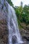 Impressive waterfall in green rainforest nature background