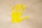 Imprint yellow color child hand isolated on brown paper. Close up. copy space. Creative, funny, artistic and happy