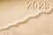 Imprints of numbers 2029 new year on a golden sand waves