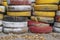 An impromptu fence made of old waste car tires, which are painted in different colors.