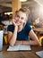 Improve your quality of life with higher education. Portrait of a young student studying in a cafe.