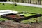 Improvised raised garden bed box made from wooden boards and concrete blocks filled with young Lettuce or Lactuca sativa organic