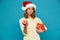 Impudent woman in sweater and christmas hat holding big gift