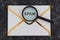 Inbox clean-up concept,  email envelope with Spam text on it and magnifying glass analyzing it