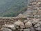 Inca house seen from behind stone walls at Machu Picchu historic site