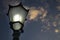 An incandescent bulb properly covered with glass glowing in an antique street lamp post.The medieval european lamp post is made of