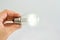 Incandescent lamp in a female hand on a white background. close-up. Electricity economy concept.