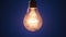 Incandescent Lamp Lights Up and Flickers on Dark Blue Background