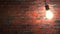 Incandescent lamp swinging in dark brickwall room, seamless loop