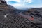 Incandescent lava flow detail on the Etna volcano in Sicily in the Valle del Bove with smoke and lava flow canal