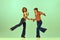 Incendiary dance. Emotional man and woman in retro style clothes dancing disco dance over green background. Concept of