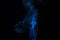 Incense stick with blue smoke against black background