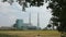 Incineration plant framed by a tree\'s leaves