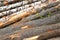 Inclined pile of logs of birch bark linden gray background many wooden base