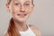 Inclusive Beauty. Girl with freckles standing  on grey smiling playful close-up