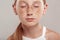 Inclusive Beauty. Girl with freckles standing isolated on grey closed eyes thinking close-up