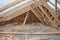 Incomplete attic house roof wooden frame construction.  Unfinished attic house rooftop roofing construction with trusses, wooden