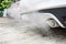 Incomplete combustion creates poisonous carbon monoxide from exhaust pipe of white car, air pollution concept