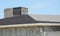 Incomplete rooftop roofing construction works with asphalt shingles and chimney repair  during house renovation