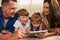 Incorporating technology into family time. an adorable brother and sister using a digital tablet with their parents on