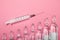 Increasing dependence on injections. Syringe and ampoules on a pink background