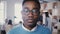 Incredible close-up portrait of handsome young African American man in glasses smiling at camera in busy office 4K.