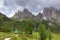 Incredible nature landscape in Dolomites Alps. Spring green blooming meadow. Panorama of Dolomites,Italy. Young woman