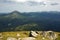 An incredible panoramic view of the summer Carpathian Mountains from the top of Mount Petros. Rocks in the foreground