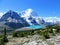 An incredible view of a beautiful turquoise lake at the base of two huge mountains and a glacier in Mount Robson Provincial Park