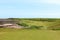 An incredible view of a classic links golf hole with pot bunkers in Scotland with the ocean in nearby