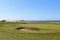 An incredible view of a golf hole in Scotland with the ocean in the background