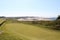 An incredible view of a golf hole in Scotland with the ocean in the background