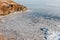 Incredible winter landscape, cold frozen sea covered with small round icicles, blue clear sky against the backdrop of mountains