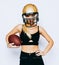 An incredibly beautiful blonde girl in a helmet posing in a black outfit and holding a ball. Sport. Match. American