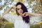 Incredibly tender girl in blossoms, on a background of a tree with white flowers, a model in a white boho dress