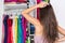 Indecision woman choosing outfit in clothes closet