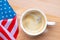 Independence Day USA concept. Memorial Day. Cup of coffee with American flag on white background top view
