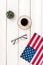 Independence day of USA with flag, glasses, coffee, plant on white wooden background top view