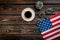 Independence day of USA with flag, glasses, coffee, plant on wooden background top view mockup