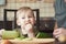 Independent blond boy cuts cucumber on wood Board