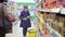 Independent teenager in the supermarket with a basket for products