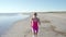 Independent young woman athlete running on beach exercising female runner sprinting training in sunny seaside background
