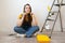 Independent young woman planning renovation apartment sitting on floor with construction tool. diy repair owner hands.