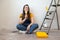 Independent young woman planning renovation apartment sitting on floor with construction tool. diy repair owner hands.